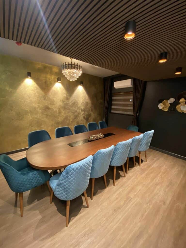 The private dining room with an oval table set for dinner beneath a crystal chandelier