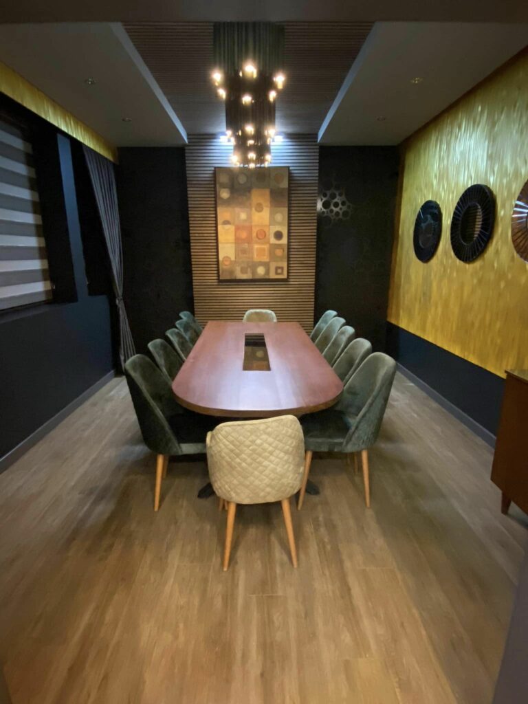 Detail of the private room: gold textured wall panels, candlelight and set glassware